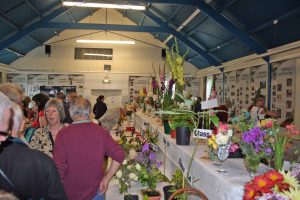 People in a village hall looking at horticulture