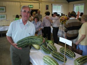 A man displaying a large marrow at Youlgrave Show